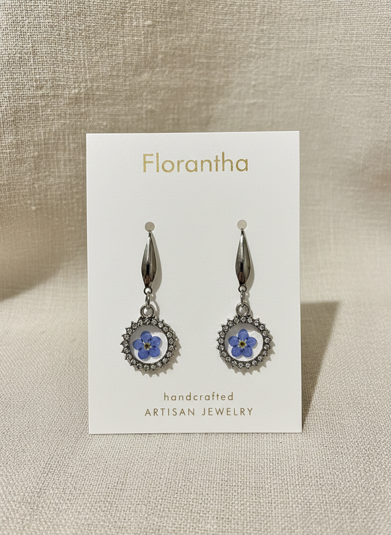 Florantha earrings on a branded card with a beige background