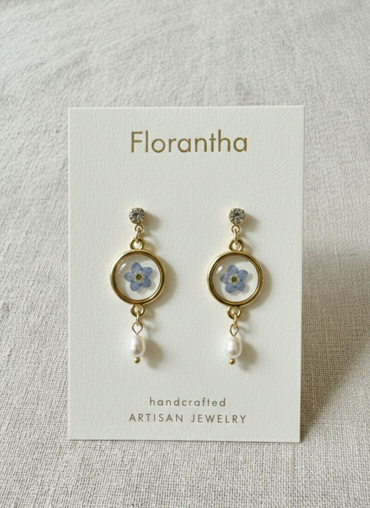 Florantha earrings on a card with a floral design on a gray background