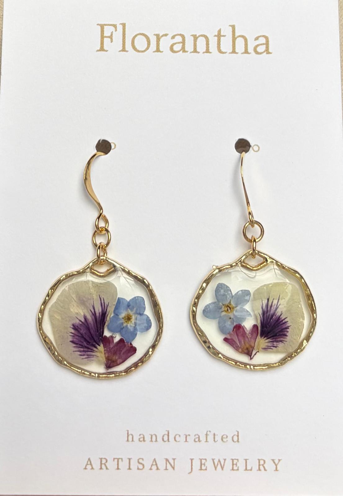 Floral earrings on a Florantha branded card with a white background