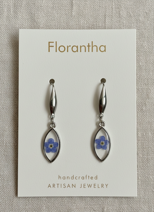 Florantha earrings with floral details on a gray textured background