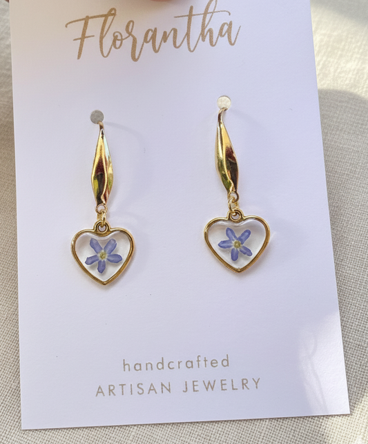 Heart-shaped earrings with floral design on a 'Florantha' branded card.