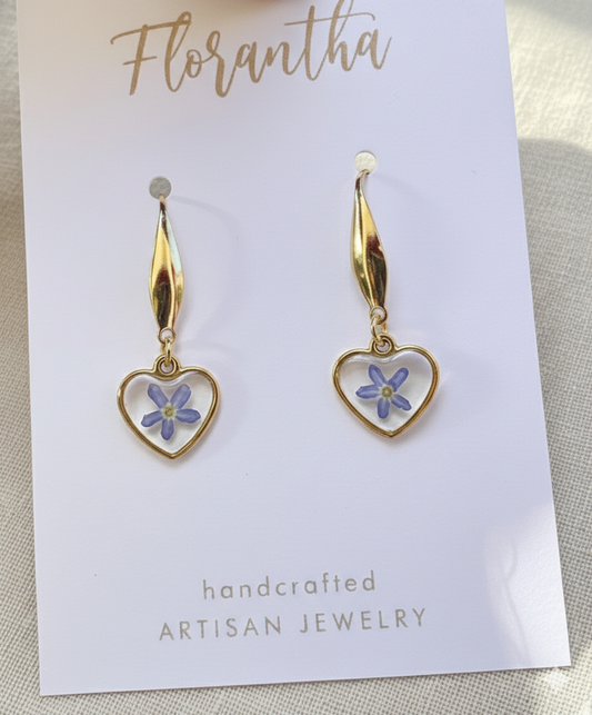 Heart-shaped earrings with floral details on a 'Florantha' branded card.