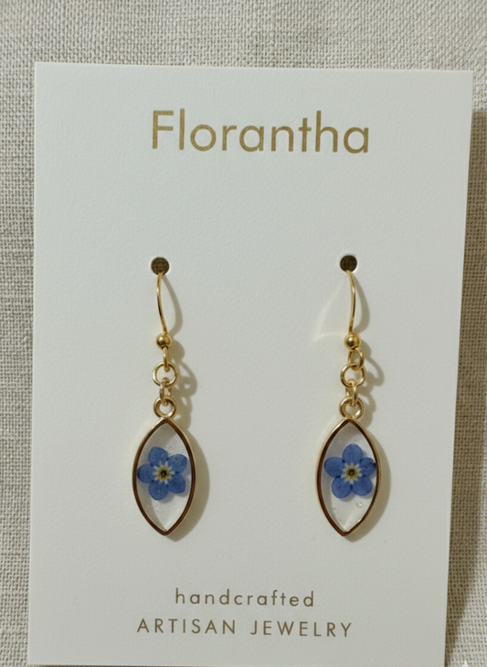 Florantha earrings with blue floral designs on a white card.