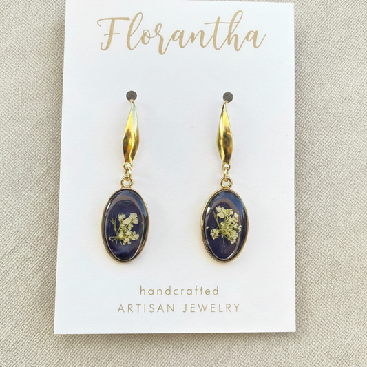 Pair of earrings on a 'Florantha' branded card with a beige background