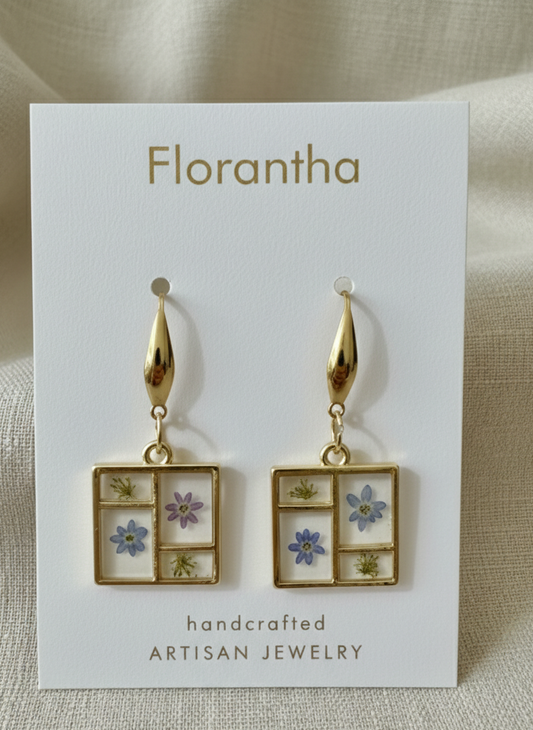 Florantha earrings on a display card with floral designs.