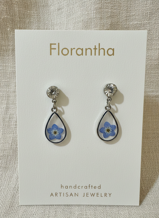 Florantha earrings on a branded card with floral design