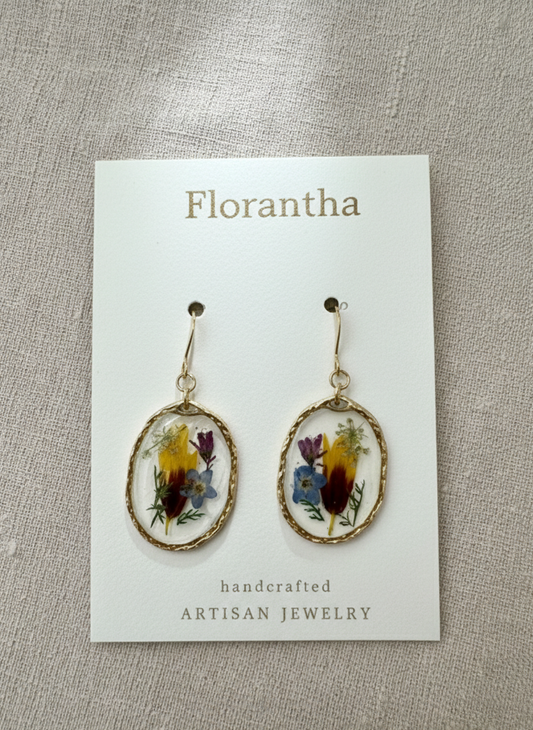 Floral earrings on a 'Florantha' branded card against a textured beige background