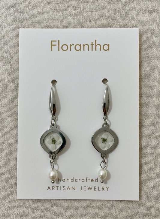 Florantha earrings on a branded card with a beige background
